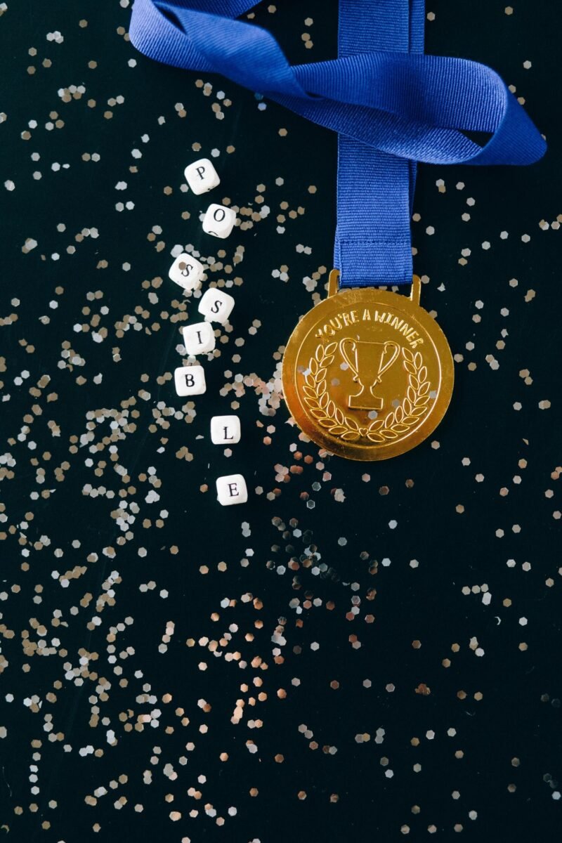 Close-up of a gold medal with the word 'POSSIBLE' on blocks, symbolizing achievement.